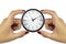 Two female hands holding a clock on white background keep time c