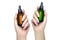 Two female hands holding up dropper bottles without label. Cosmetology, beauty and skincare concept