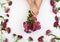 two female hands with light smooth skin and buds of a blossoming Turkish carnation on a white background