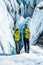 Two female ice climbers looking into a huge crevasse on a glacier in remote Alaska