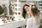 Two female make-up artist working with young woman model in dressing room.