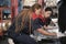 Two female mechanic workers are changing car wheel tires at a service garage.