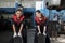 Two female mechanic workers are pushing car wheel tires at a service garage.