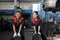 Two female mechanic workers are pushing car wheel tires at a service garage.