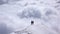 Two female mountain climbers on a narrow summit ridge high above cloud banks in the valleys below