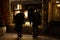 Two female pedestrians standing in front of a store window in dark evening. Focus on window