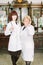 Two female pharmacists in pharmacy. Young pretty girl pharmacist and middle-aged woman pharmacist smiling and standing