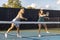 Two Female Pickleball Players in Rally at Net