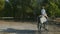 Two Female riders in riding clothes and helmets riding horses in a circle