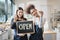 Two female shopkeepers show an open signboard in the refill store shop