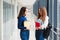 Two female students stand in the corridor of the college with books