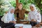 two female students and teacher in veil smiling showing cellphone