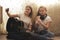 Two female teens playing musical instruments and making selfie sitting on the floor at home