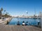 Two female tourists rest surrounded by seagulls in the old port of the city of Barcelona. Catalonia, Spain