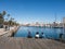 Two female tourists rest surrounded by seagulls in the old port of the city of Barcelona. Catalonia, Spain