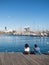 Two female tourists rest surrounded by seagulls in the old port of the city of Barcelona. Catalonia, Spain