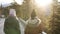 Two female tourists walking in slow motion on a long road through the countryside towards the snowy mountain peaks and