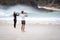 Two females taking photographs on a beach with mobile phones