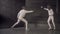 Two fencers man and woman have fencing match indoors