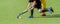 Two field hockey player, fighting for the ball on the midfield during an intense match on artificial grass