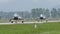 Two fighter jets on the air base runway under heavy rain and bad weather