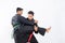 Two fighters in black pencak silat uniform fight in locks and slams