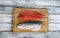 Two fillet, skin side up and down, of trout salmon on cutting board with white rustic wooden table setting