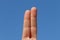 Two fingers with sky background