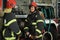 Two firefighters in protective clothing in helmets