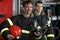 Two firefighters in protective suits standing