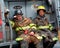 Two firefighters taking a break ifrom fire fighting at a house fire t