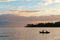 Two fishermen in a boat going fishing early in the morning at dawn