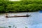 Two fishermen in a canoe navigating the Jaguaripe River