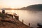 Two fishermen with fishing nets in the Mekong River at sunset. S