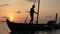 Two fishermen wash old boat at sunset in the Indian Ocean. Slow motion