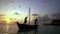 Two fishermen wash old boat at sunset in the Indian Ocean. Slow motion