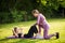 Two fit girlfriends doing partner sit-up exercise with high-five in summer park