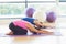 Two fit women bending over on exercise mats in fitness studio