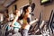 Two fit women running on treadmills in modern gym