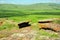 Two flat sacrificial stones on top of a hill overlooking a picturesque valley