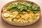 Two flavor pizza: Arugula and zucchini with corn kernels. Detail