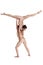 Two flexible girls gymnasts in beige leotards performing complex elements of gymnastics using support, posing isolated