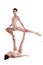 Two flexible girls gymnasts in beige leotards are performing exercises upside down using support and posing isolated on