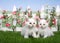 Two fluffy white kittens in a backyard flower garden