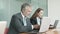 Two focused business colleagues sitting together at desk