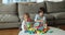 Two focused cute sibling kids playing building blocks at home