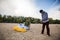 Two focused men lay out a kite, paraglider