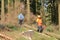 Two forest workers as lumberjack in protective clothing and with chainsaw in the forest