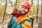 Two forest workers carry a tree trunk