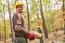 Two forest workers carry tree trunk at wood harvest